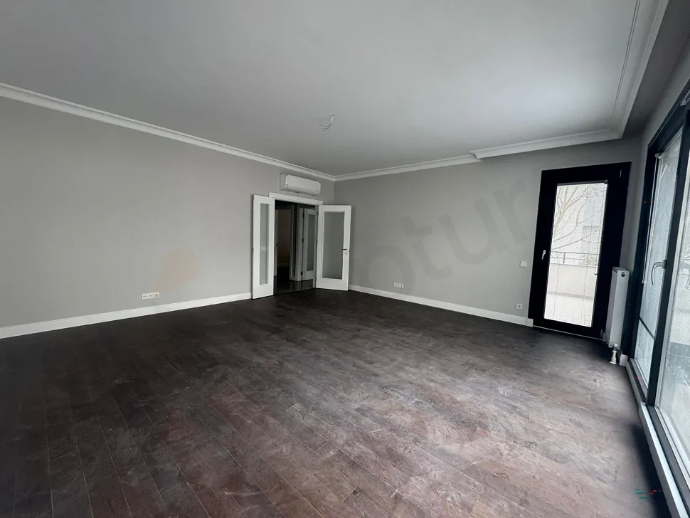 Spacious and bright living room area with large windows.