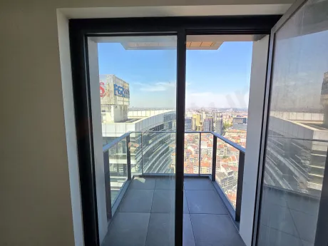 Spacious and airy balcony of a modern apartment opening to a city view.