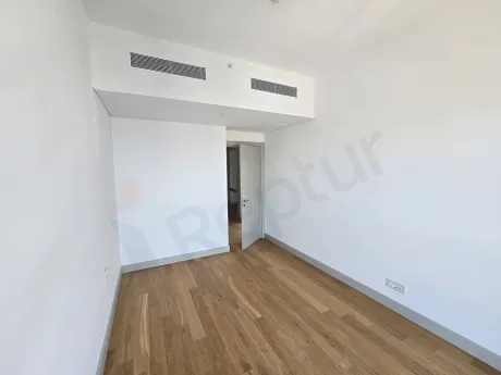 Modern designed, spacious bedroom with large windows and natural sunlight.