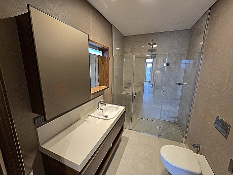 Modern designed, bright and spacious bathroom. White ceramics, shower cabin, and stylish sink.