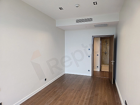 Modern bedroom interior, wooden parquet floor, cream colored walls, large window and stylish bed