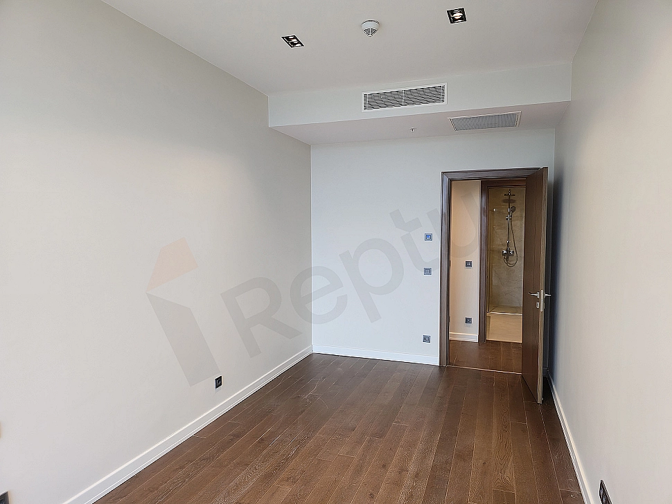 Modern bedroom interior, wooden parquet floor, cream colored walls, large window and stylish bed