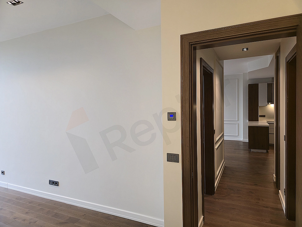 Modern apartment corridor with wooden floor, white walls and built-in closet