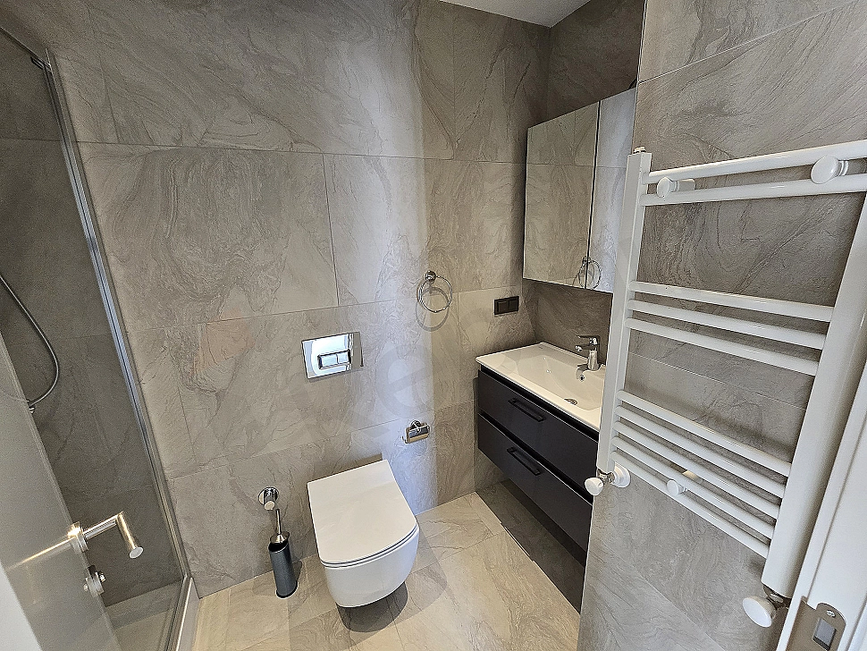Luxurious bathroom with modern design, white ceramics and large mirror.