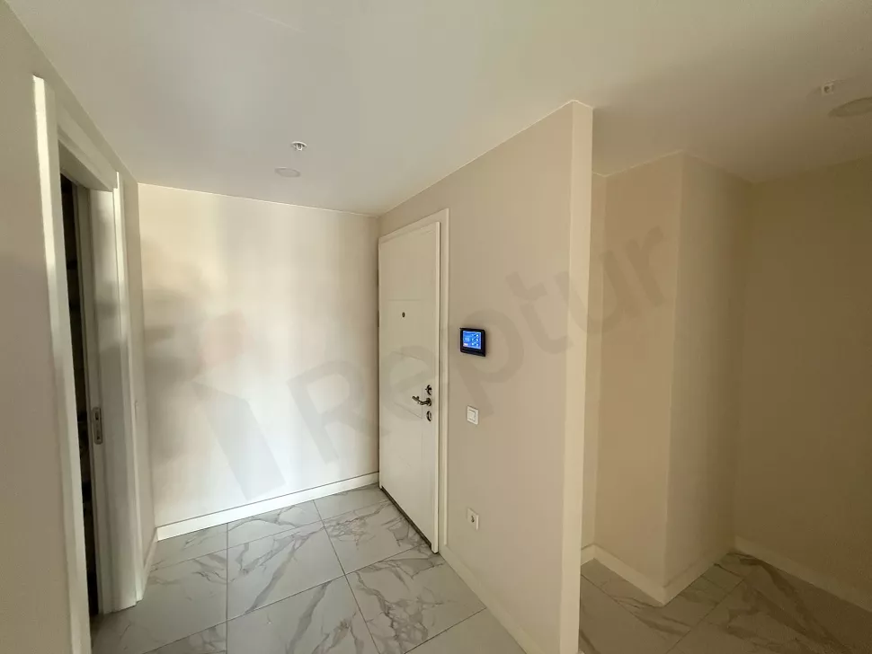 View of the entrance door and spacious hallway of a modern apartment.