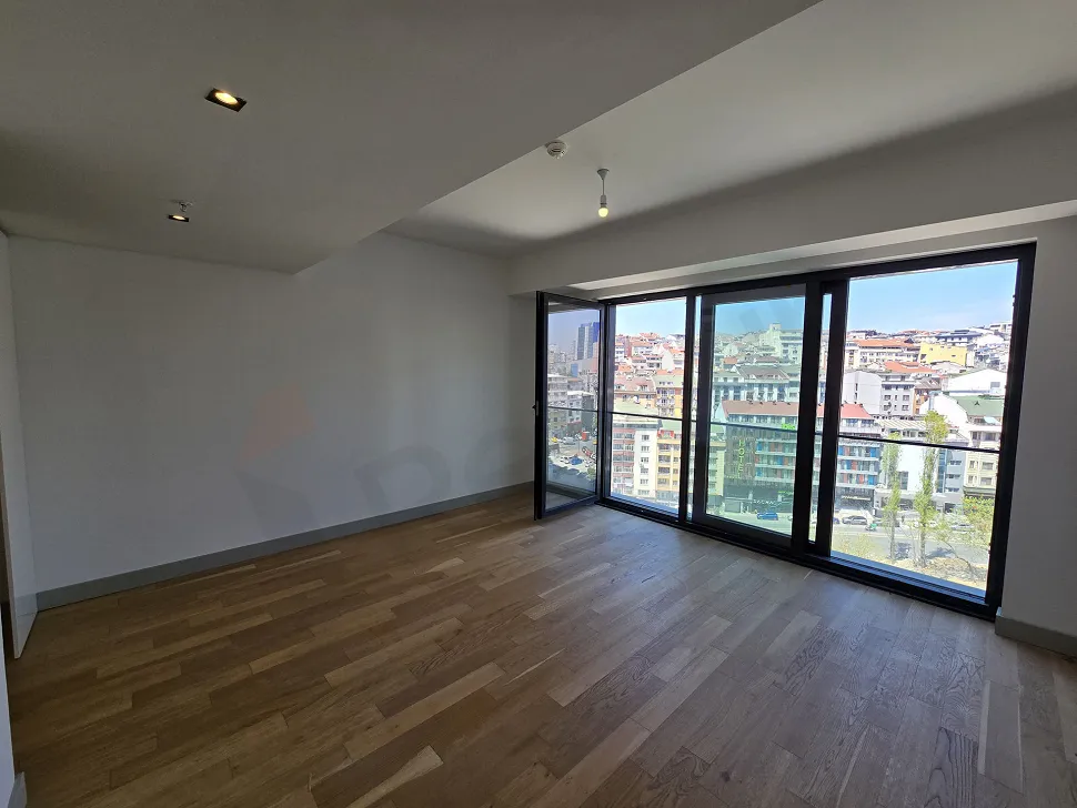 Modern and spacious living room area with large windows in a luxury project in Sisli.
