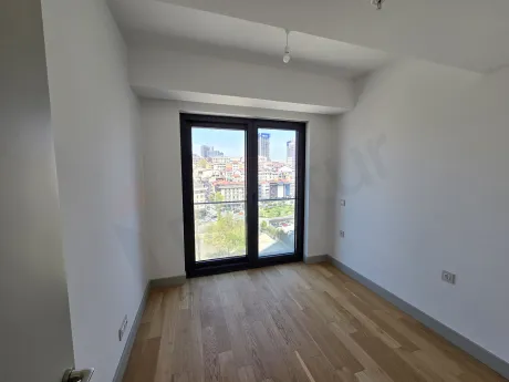 Modern bedroom area with large windows and natural light in a 2+1 apartment for sale in Sisli, Istanbul.
