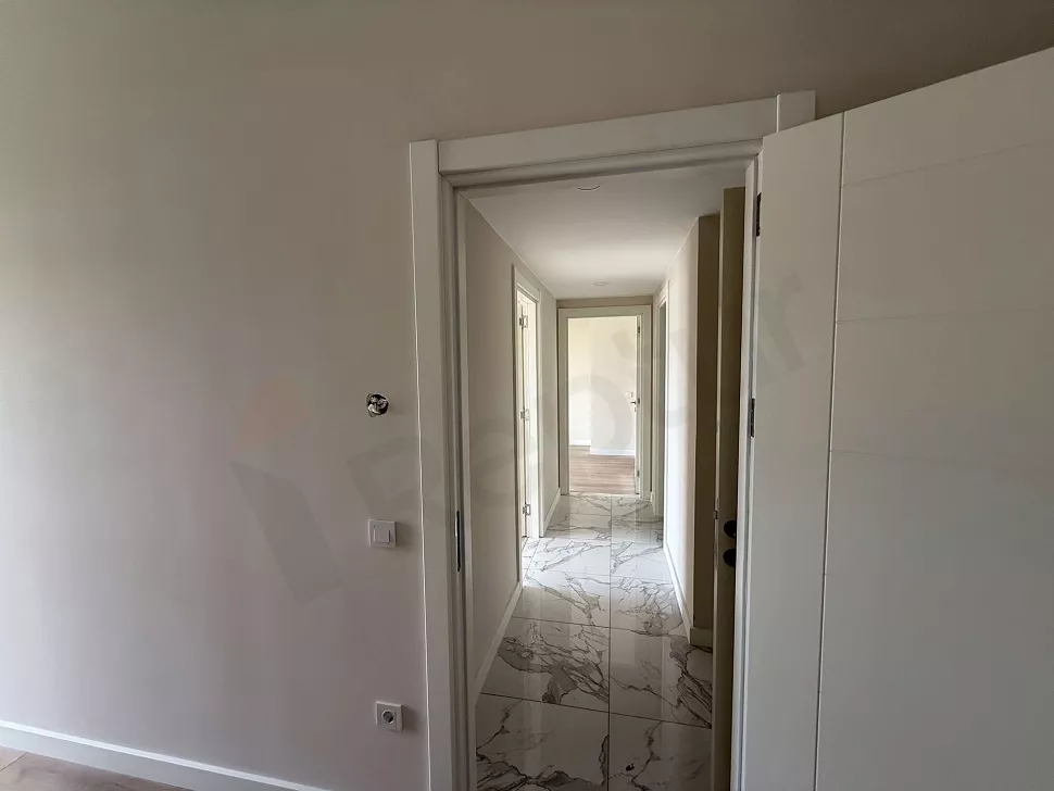 Interior view of a modern, spacious, and bright apartment corridor.