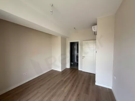 Modern bedroom interior with large windows and natural light in a new building.