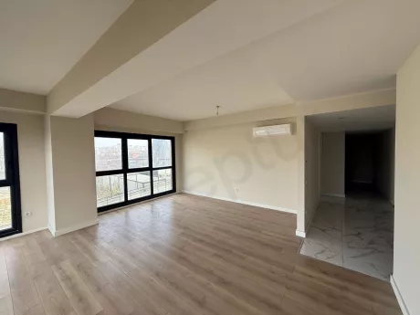 Spacious and bright living room area with large windows in a modern building.
