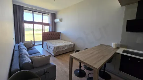 Spacious and bright living room area of a modern 1+1 apartment.