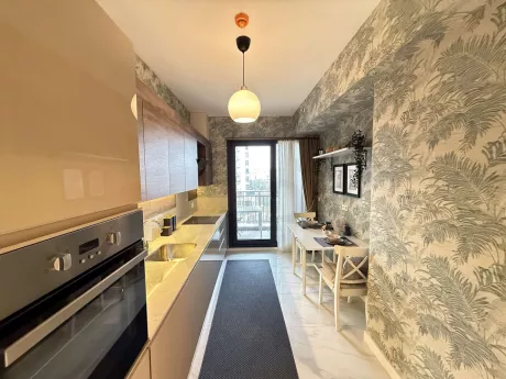 Modern furnished kitchen interior with stylish cabinets and built-in appliances.