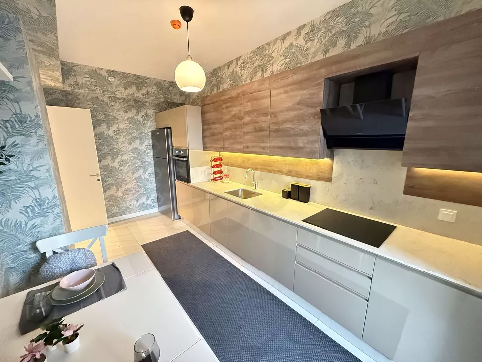 Modern and stylishly designed furnished kitchen area with built-in appliances and cabinets.