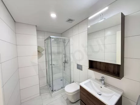 Modern bathroom interior with a large mirror and stylish cabinets.