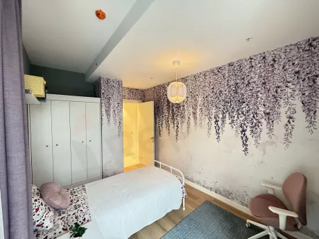 A spacious and bright bedroom view decorated with modern furniture.