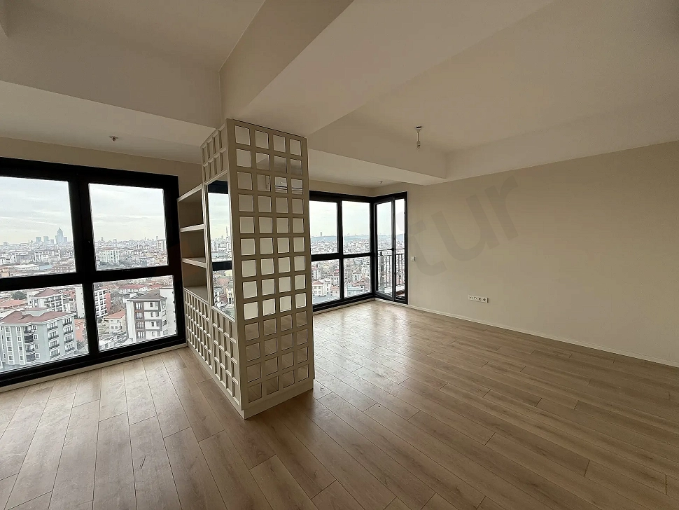 Spacious living room area with modern architecture, large windows, and natural daylight.