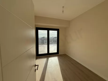 Modern and spacious empty bedroom interior with large windows and bright natural light.