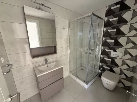 Modernly designed spacious bathroom with high-quality ceramic tiling and stylish fixtures.