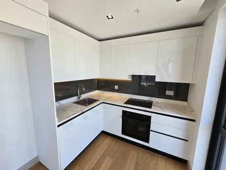 Modern and stylish open-plan kitchen design within a contemporary apartment interior.