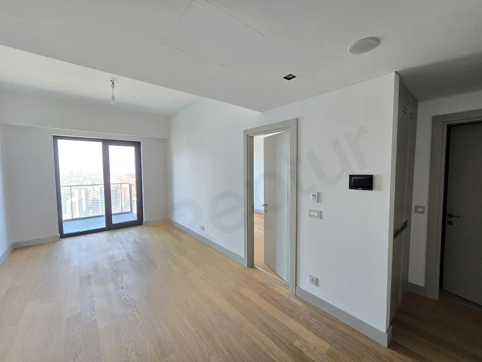 Spacious and bright modern living room interior with large windows and a city view.