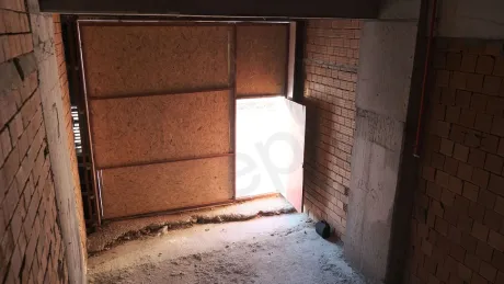 Interior view of an unfinished shell-and-core commercial shop with concrete walls and high ceilings.