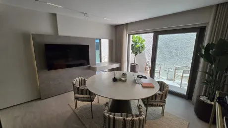 Bright dining room area with large glass doors opening onto a terrace.