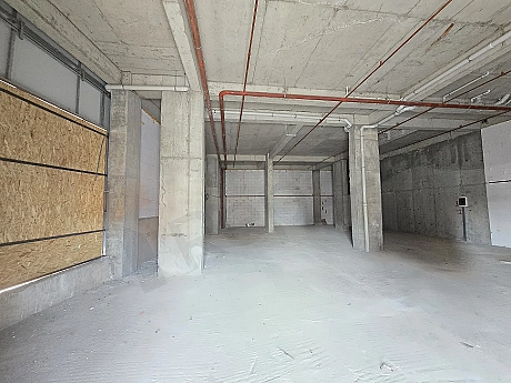Interior view of a spacious unfinished shell-and-core commercial shop with concrete columns