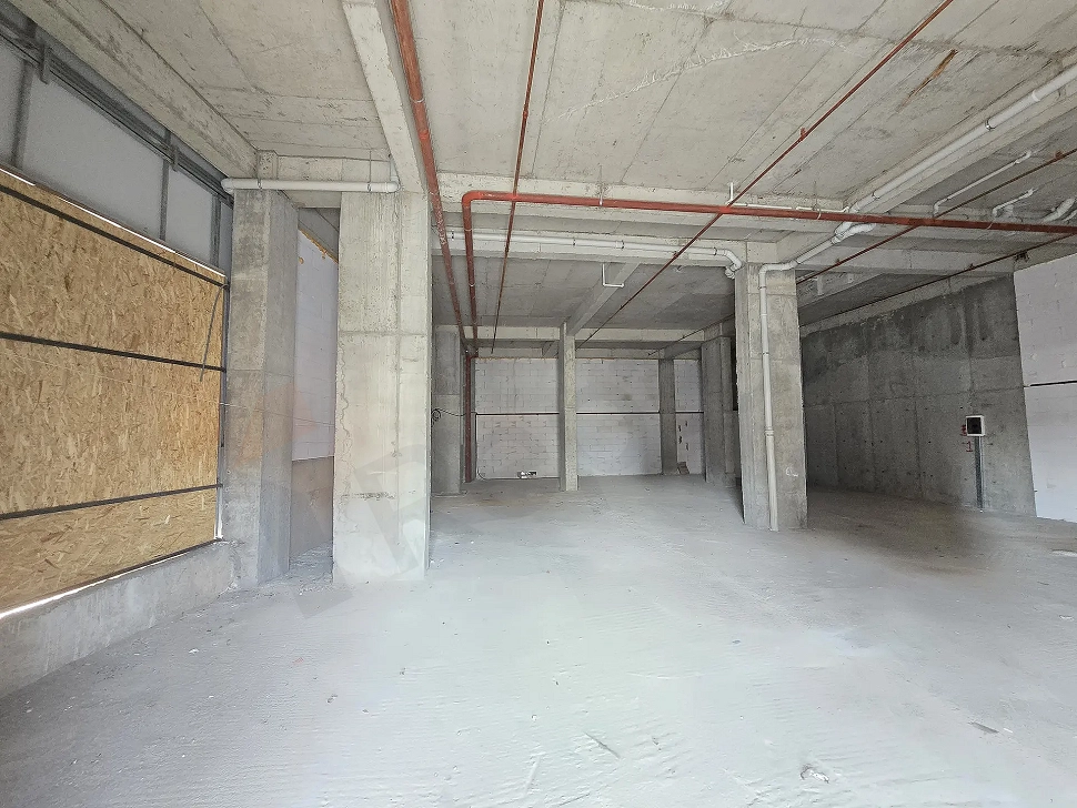 Interior view of a spacious unfinished shell-and-core commercial shop with concrete columns