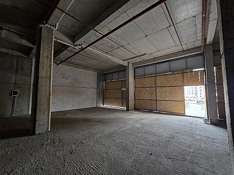 Unfinished shop interior with high ceilings and concrete columns