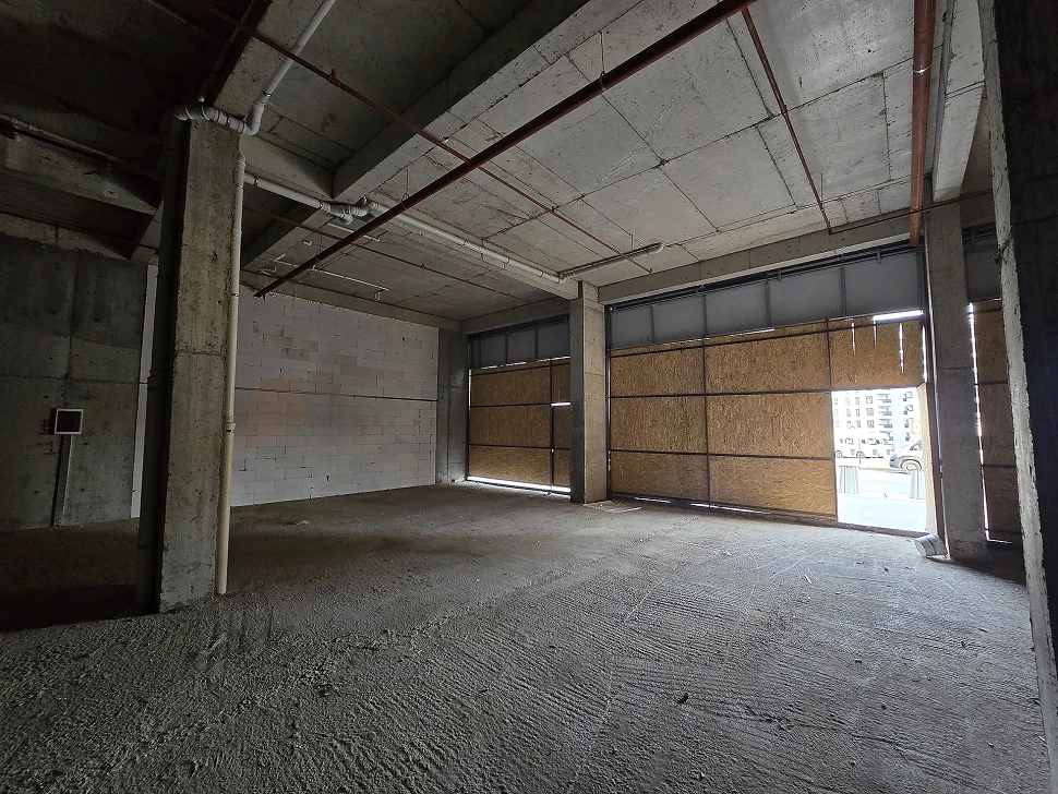 Unfinished shop interior with high ceilings and concrete columns