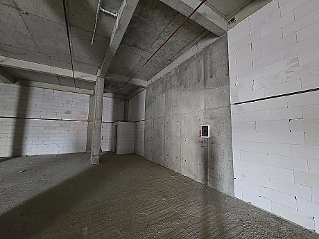 Interior view of a large unfinished commercial shop space with concrete structure