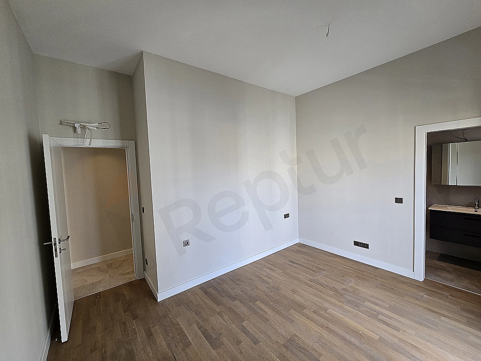 Modern bedroom interior: double bed, nightstands, lamps, rug, and minimalist design.