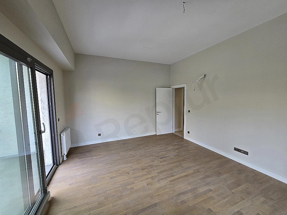 Modern living room: Gray corner sofa, wooden coffee table, decorative pillows and bright window detail.