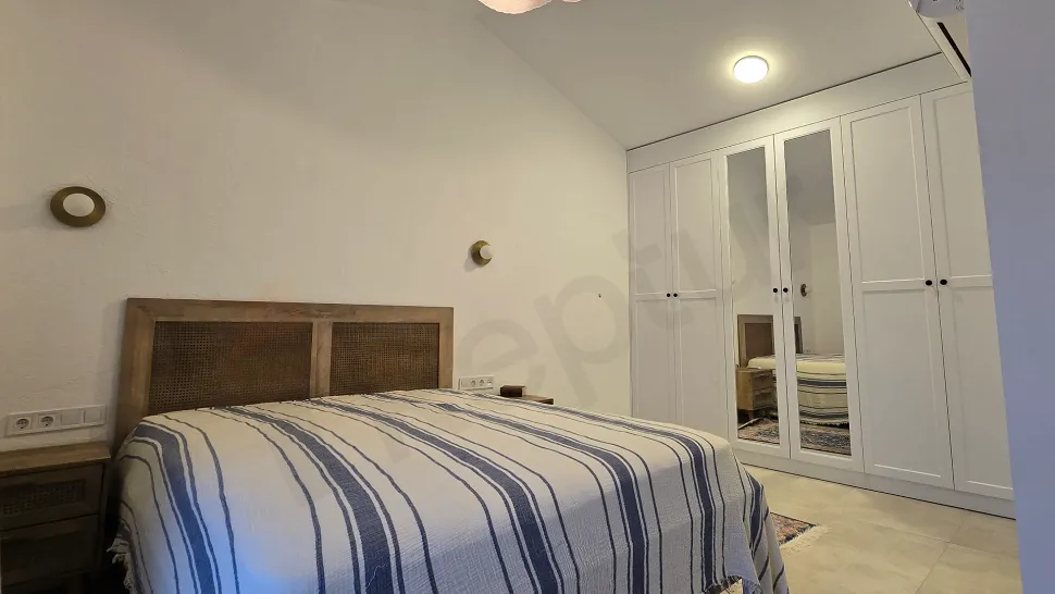 View of a spacious, modernly decorated, and furnished bedroom.