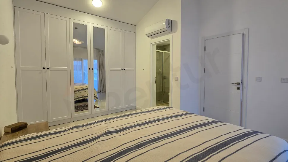 Image of a spacious and bright bedroom furnished with modern furniture.