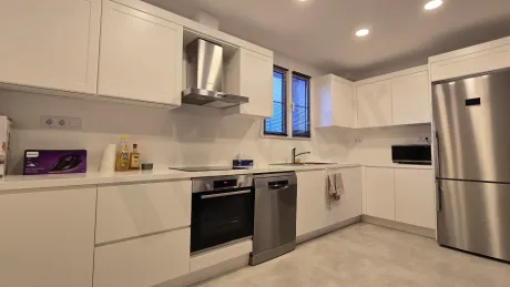 Spacious villa kitchen with modern design, white cabinets, and built-in appliances.