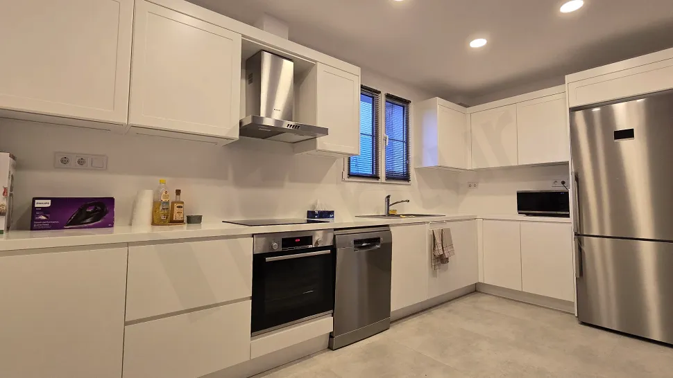 Spacious villa kitchen with modern design, white cabinets, and built-in appliances.