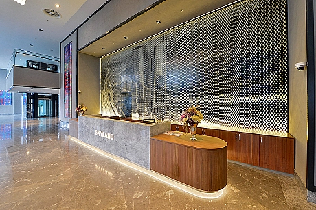 Modern building entrance facade with glass and metal details, landscape arrangement