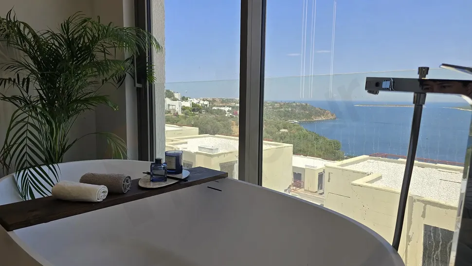 Modern bathroom interior with a scenic sea view and large windows.