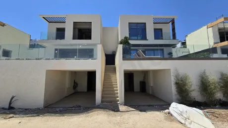 Exterior architectural view of two modern villas with natural stone cladding.