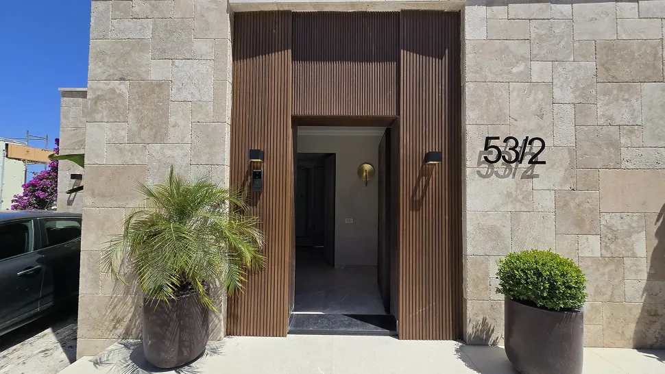 Villa entrance featuring a wooden door and natural stone exterior facade