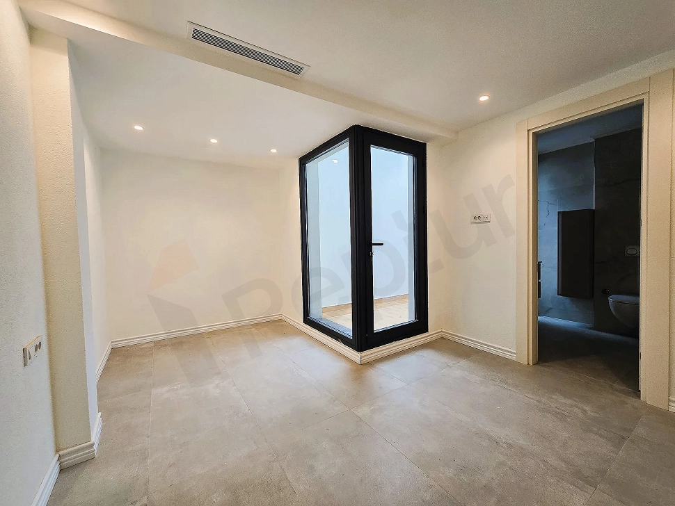 Spacious and bright bedroom with large windows in a new building in Bodrum.
