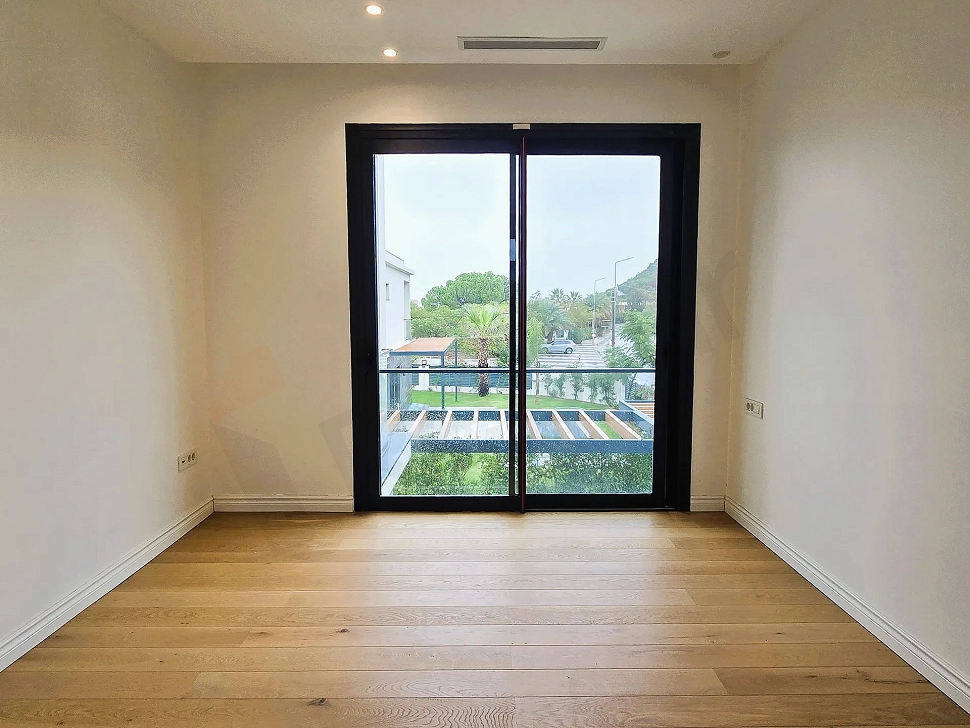 Spacious bedroom area with large windows in a modern hotel building.