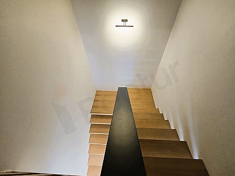 Modern interior staircase with wooden steps and stylish railings.