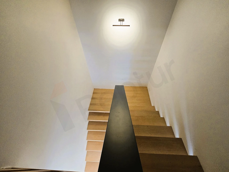 Modern interior staircase with wooden steps and stylish railings.