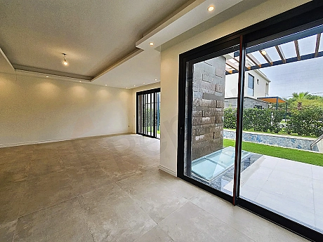 Modern and spacious living room area with large windows.
