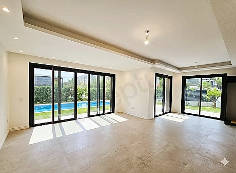 Spacious and bright empty sitting room area with modern architecture and large windows in a hotel for sale in Bodrum.