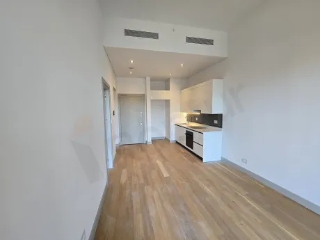 A spacious living room area with modern design and large windows letting in natural light.