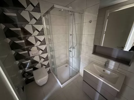 Modern bathroom design with stylish tiles and vanity unit.