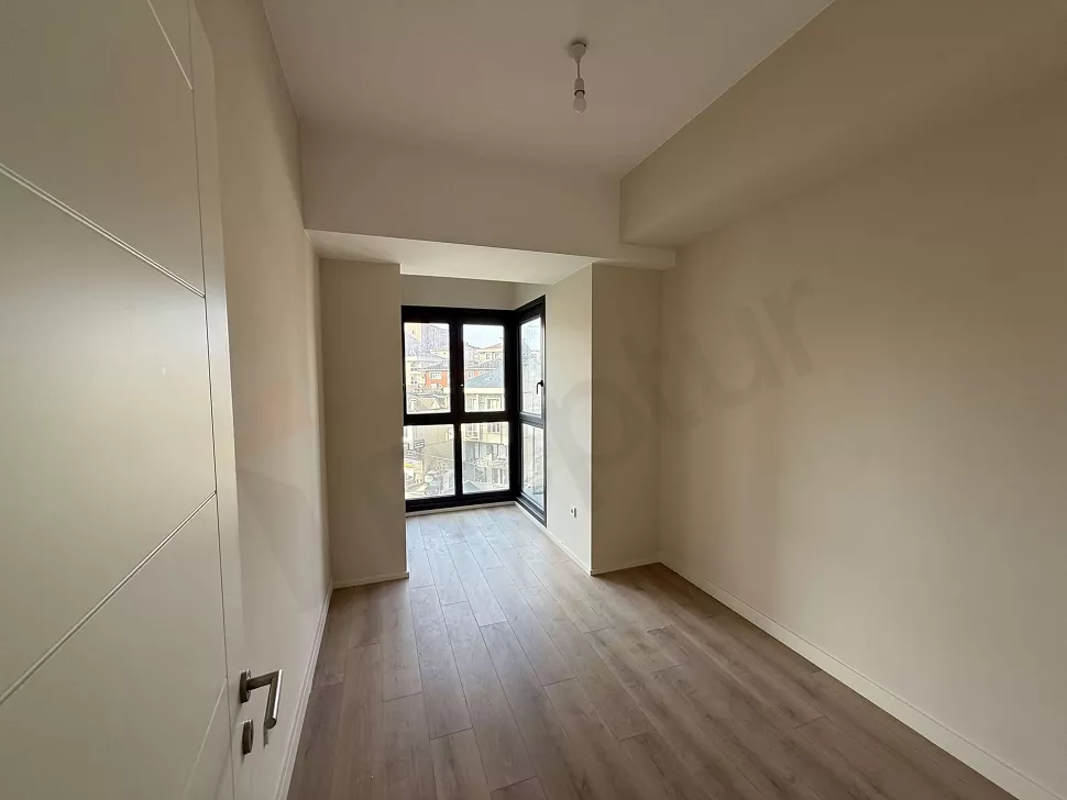 Bedroom view of a new apartment with large windows, bright and modern design.